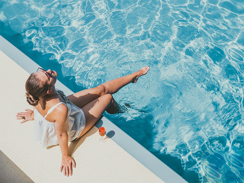 woman seating beside the pool